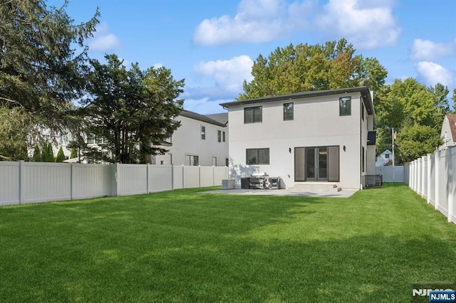 back of property featuring stucco siding, a lawn, a fenced backyard, and a patio area