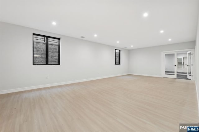 spare room featuring light wood finished floors, visible vents, recessed lighting, and baseboards