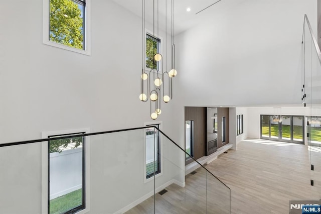 stairway featuring a towering ceiling and wood finished floors