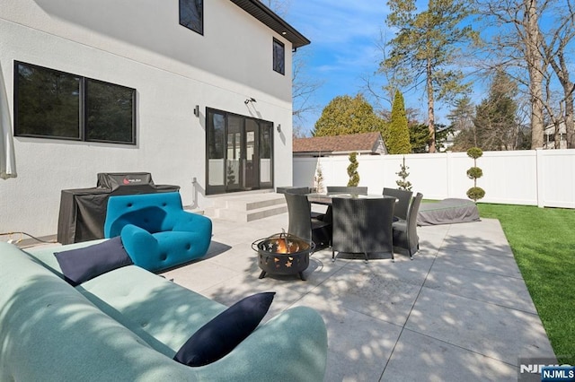 view of patio / terrace featuring french doors, an outdoor living space with a fire pit, and a fenced backyard