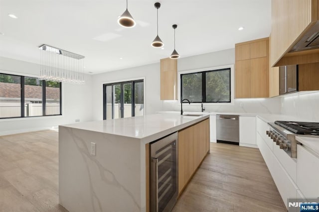 kitchen with light brown cabinets, modern cabinets, beverage cooler, and appliances with stainless steel finishes