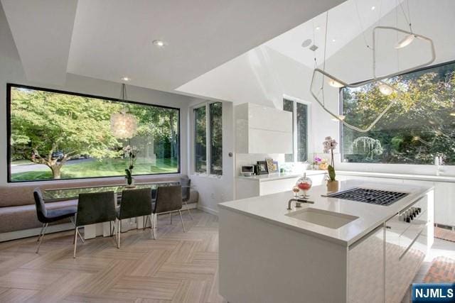 kitchen featuring a sink, a kitchen island, modern cabinets, and white cabinets