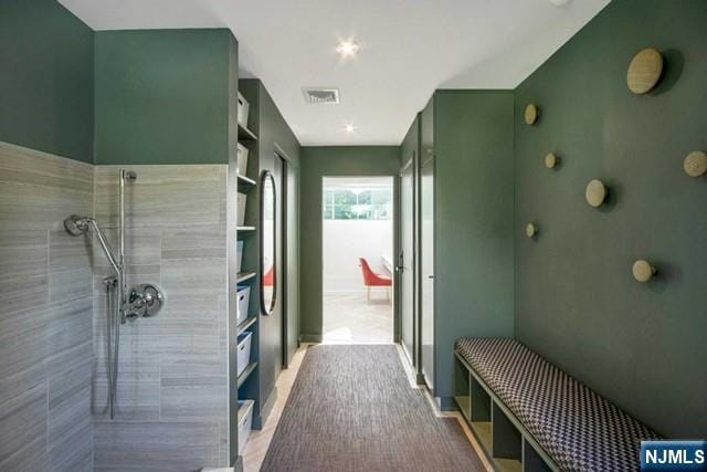 full bathroom with visible vents and tiled shower