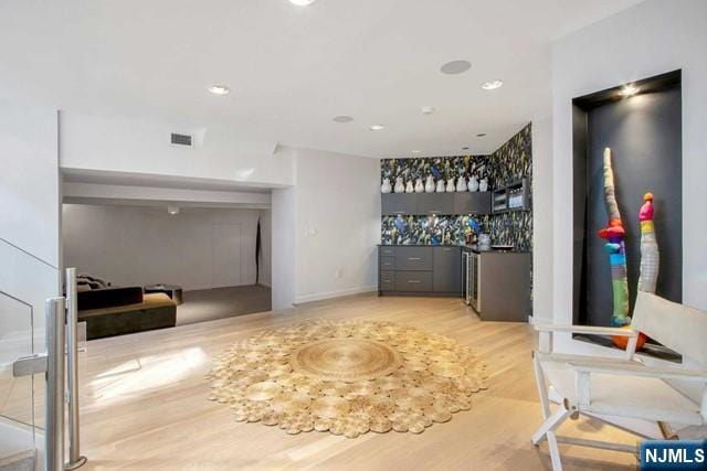 bar featuring recessed lighting, visible vents, a dry bar, and light wood finished floors