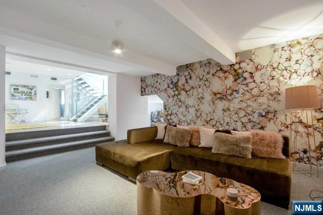 living room featuring beamed ceiling, carpet flooring, and wallpapered walls