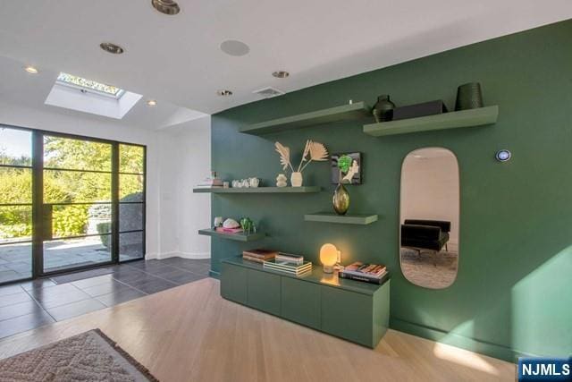 interior space with tile patterned flooring, recessed lighting, a skylight, and baseboards