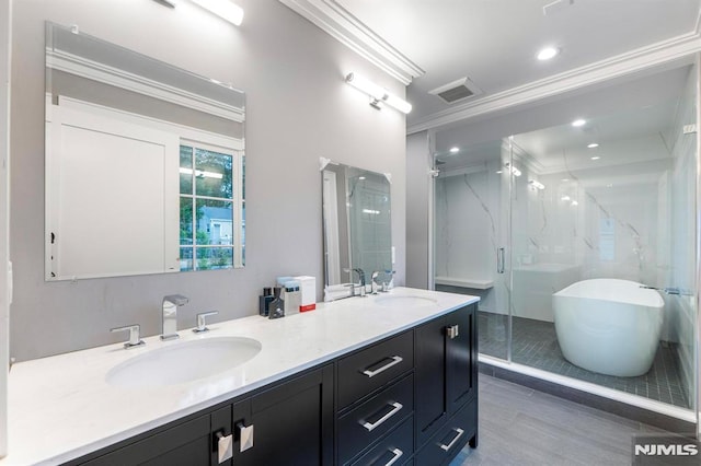 full bath with a marble finish shower, visible vents, ornamental molding, and a sink