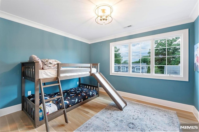 bedroom with visible vents, baseboards, and wood finished floors