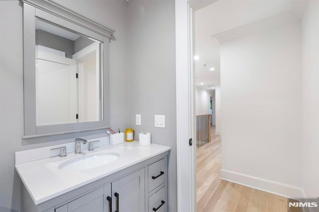 bathroom with vanity, baseboards, and wood finished floors