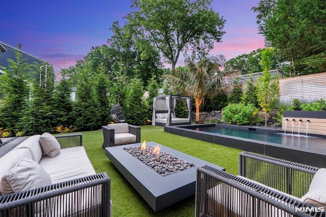 exterior space with an outdoor pool, an outdoor living space with a fire pit, and a fenced backyard