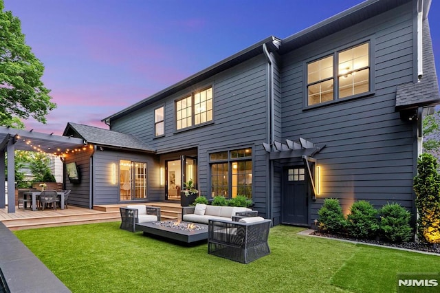 rear view of house with a deck, an outdoor living space with a fire pit, a yard, and a pergola