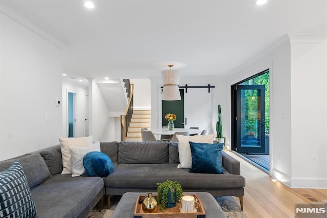 living area with light wood-style flooring, recessed lighting, stairs, crown molding, and a barn door