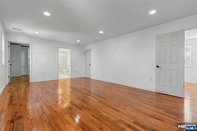 empty room featuring light wood finished floors, visible vents, recessed lighting, and baseboards