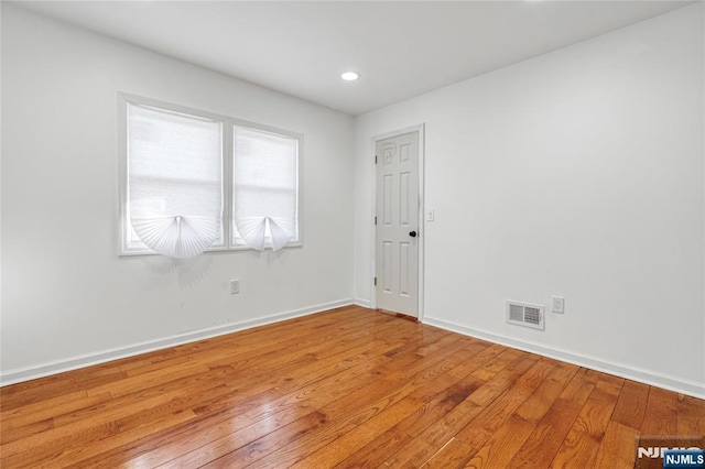 empty room with recessed lighting, visible vents, light wood-style flooring, and baseboards