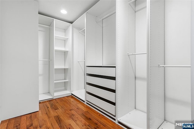 walk in closet with wood finished floors