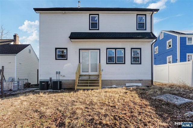 rear view of property with fence, central AC, and entry steps