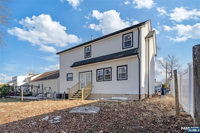 rear view of property featuring central AC unit and entry steps