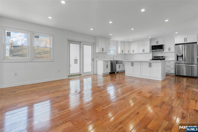 kitchen featuring white cabinetry, recessed lighting, stainless steel appliances, light wood-style floors, and light countertops