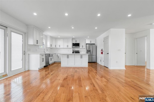 kitchen featuring light countertops, recessed lighting, light wood-style floors, and stainless steel appliances