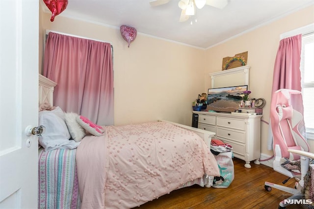 bedroom featuring dark wood finished floors, crown molding, and a ceiling fan