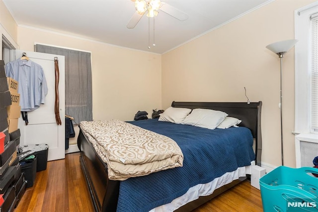 bedroom with crown molding, a ceiling fan, and wood finished floors