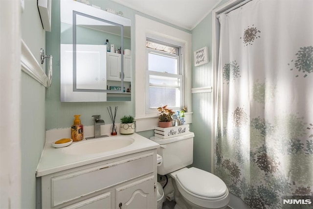 full bath featuring toilet, vanity, and a shower with curtain