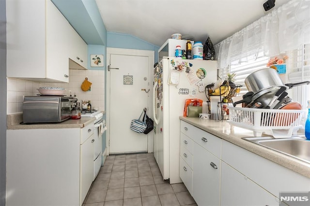 kitchen featuring backsplash, white appliances, white cabinetry, and light countertops