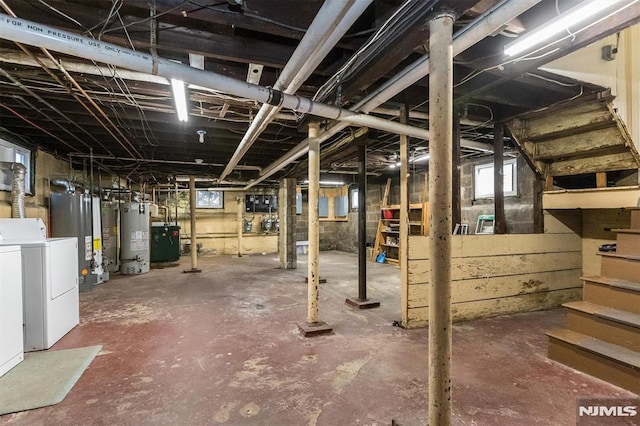 basement with water heater and independent washer and dryer