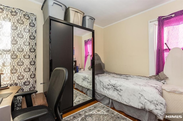 bedroom featuring crown molding and wood finished floors