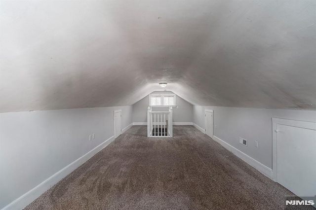 bonus room with visible vents, baseboards, carpet, and vaulted ceiling