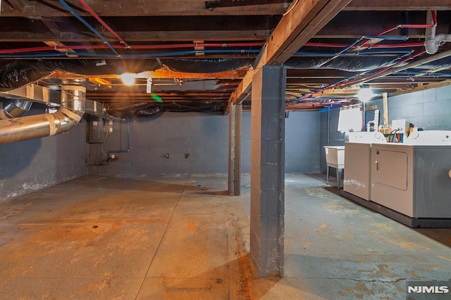 unfinished basement featuring electric panel and separate washer and dryer