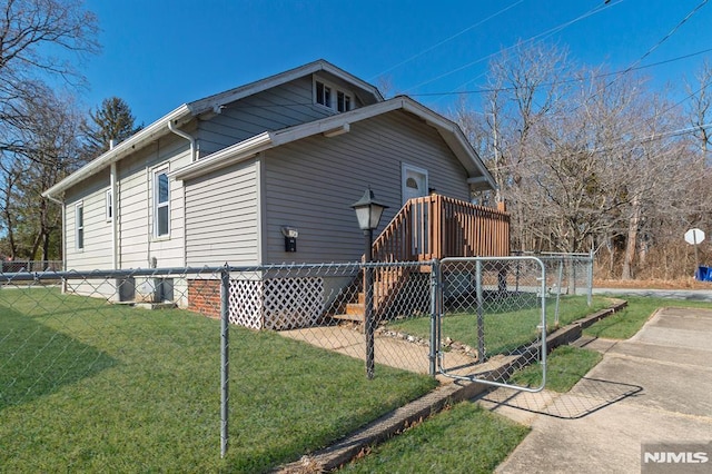 view of property exterior featuring stairs, a gate, fence, and a lawn