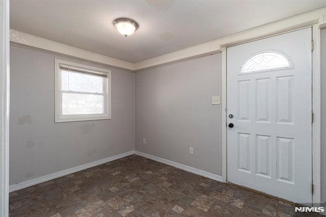 entrance foyer with baseboards and stone finish floor