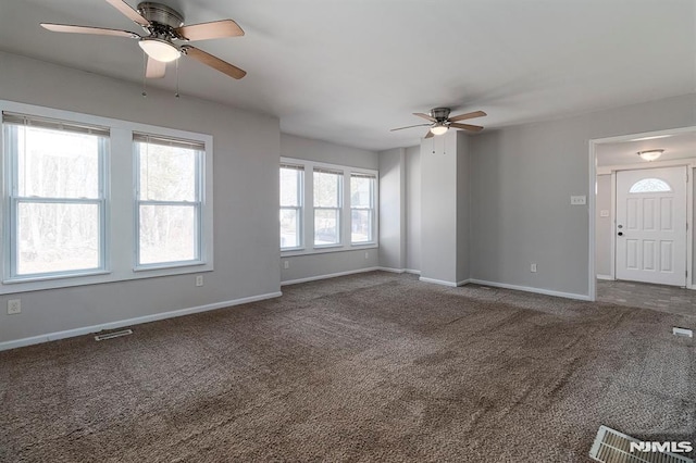 unfurnished living room with visible vents, baseboards, carpet, and a ceiling fan