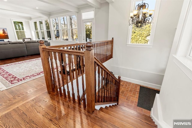 stairway featuring baseboards, beamed ceiling, recessed lighting, wood finished floors, and a notable chandelier