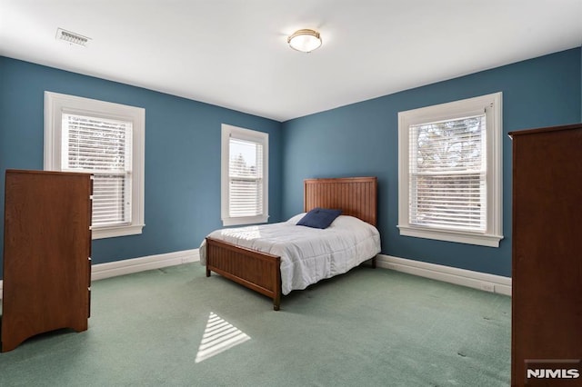 bedroom featuring visible vents, multiple windows, and baseboards