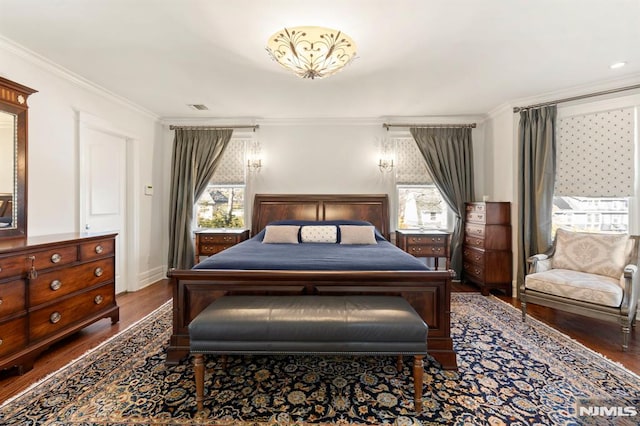 bedroom featuring visible vents, multiple windows, wood finished floors, and crown molding