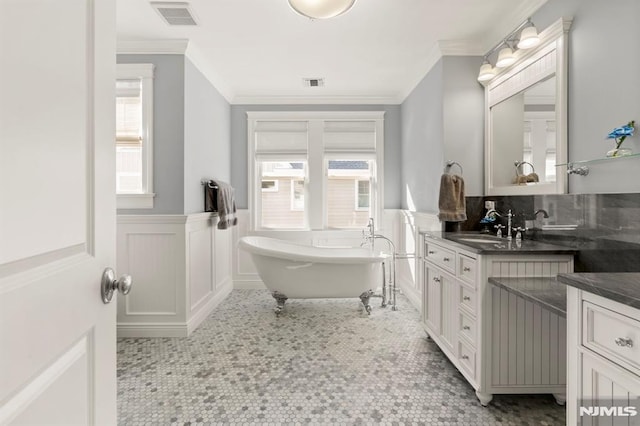 full bathroom featuring vanity, visible vents, and wainscoting