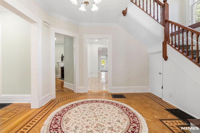 foyer featuring stairway, baseboards, visible vents, crown molding, and a notable chandelier