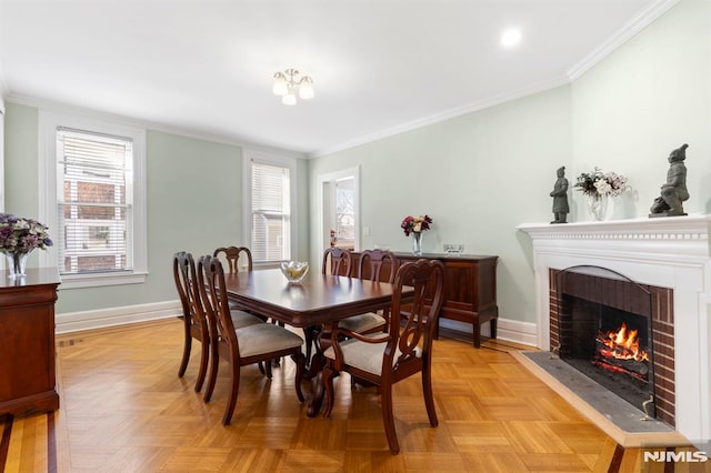 dining area featuring a brick fireplace, crown molding, and baseboards