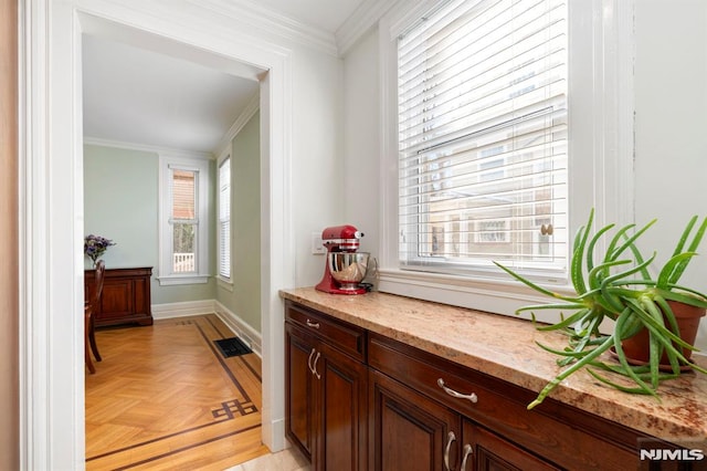 corridor featuring visible vents, baseboards, and ornamental molding