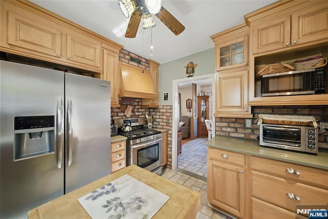 kitchen with a toaster, ceiling fan, stainless steel appliances, custom range hood, and tasteful backsplash