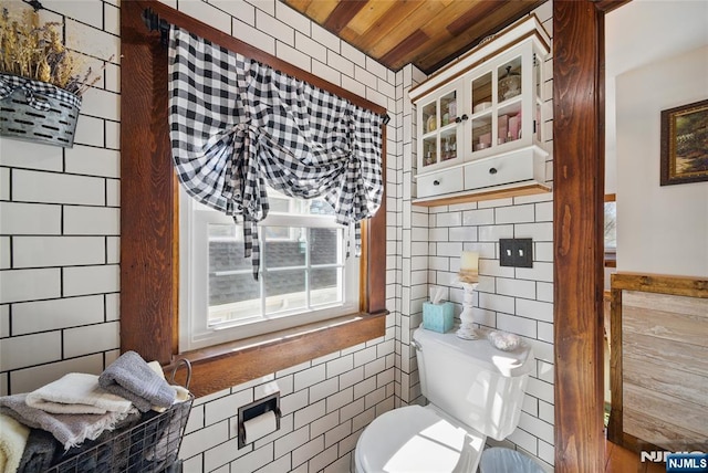 half bathroom with toilet, tile walls, and wooden ceiling