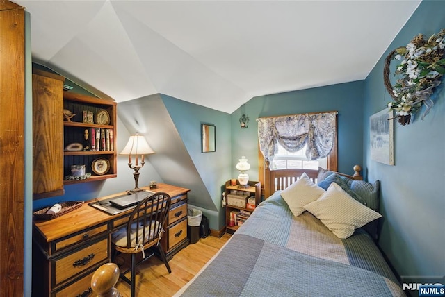 bedroom with lofted ceiling and wood finished floors