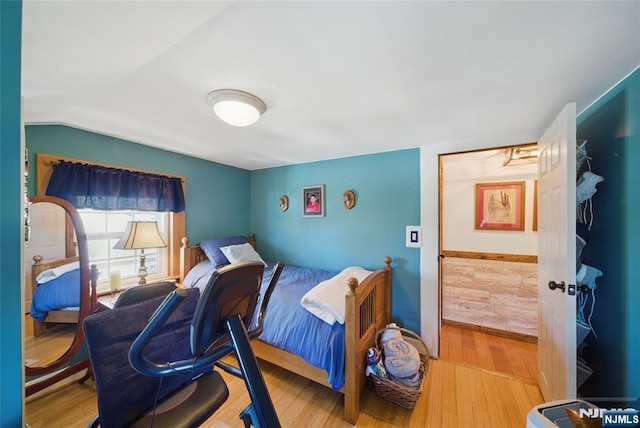 bedroom with lofted ceiling and wood finished floors