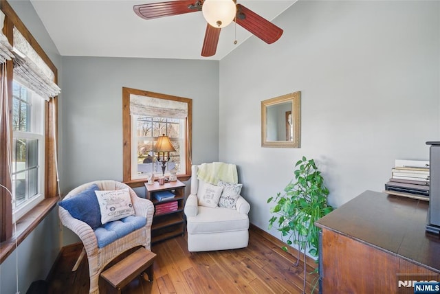 living area featuring vaulted ceiling, ceiling fan, and wood-type flooring