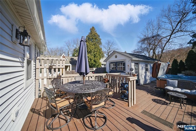 deck featuring outdoor dining area and an outbuilding