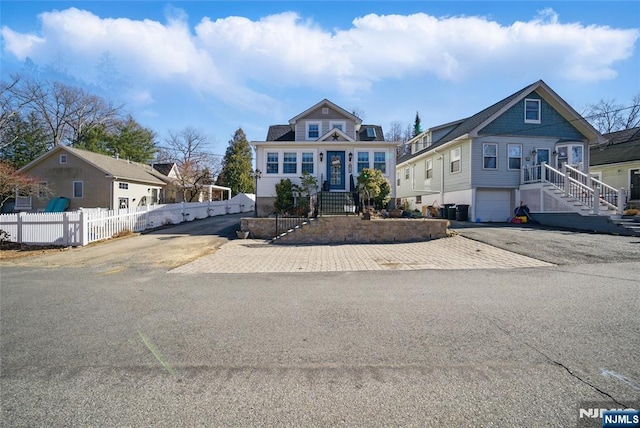 view of front of property with aphalt driveway, a garage, and fence