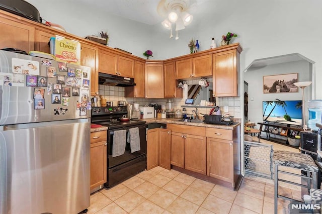 kitchen featuring backsplash, under cabinet range hood, freestanding refrigerator, electric range, and a sink