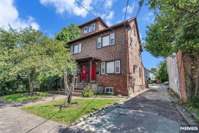 american foursquare style home with brick siding and stone siding